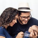 Casal segura carinhosamente o filho recém-nascido em um momento de afeto familiar
