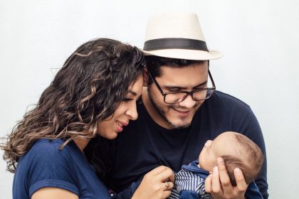 Casal segura carinhosamente o filho recém-nascido em um momento de afeto familiar