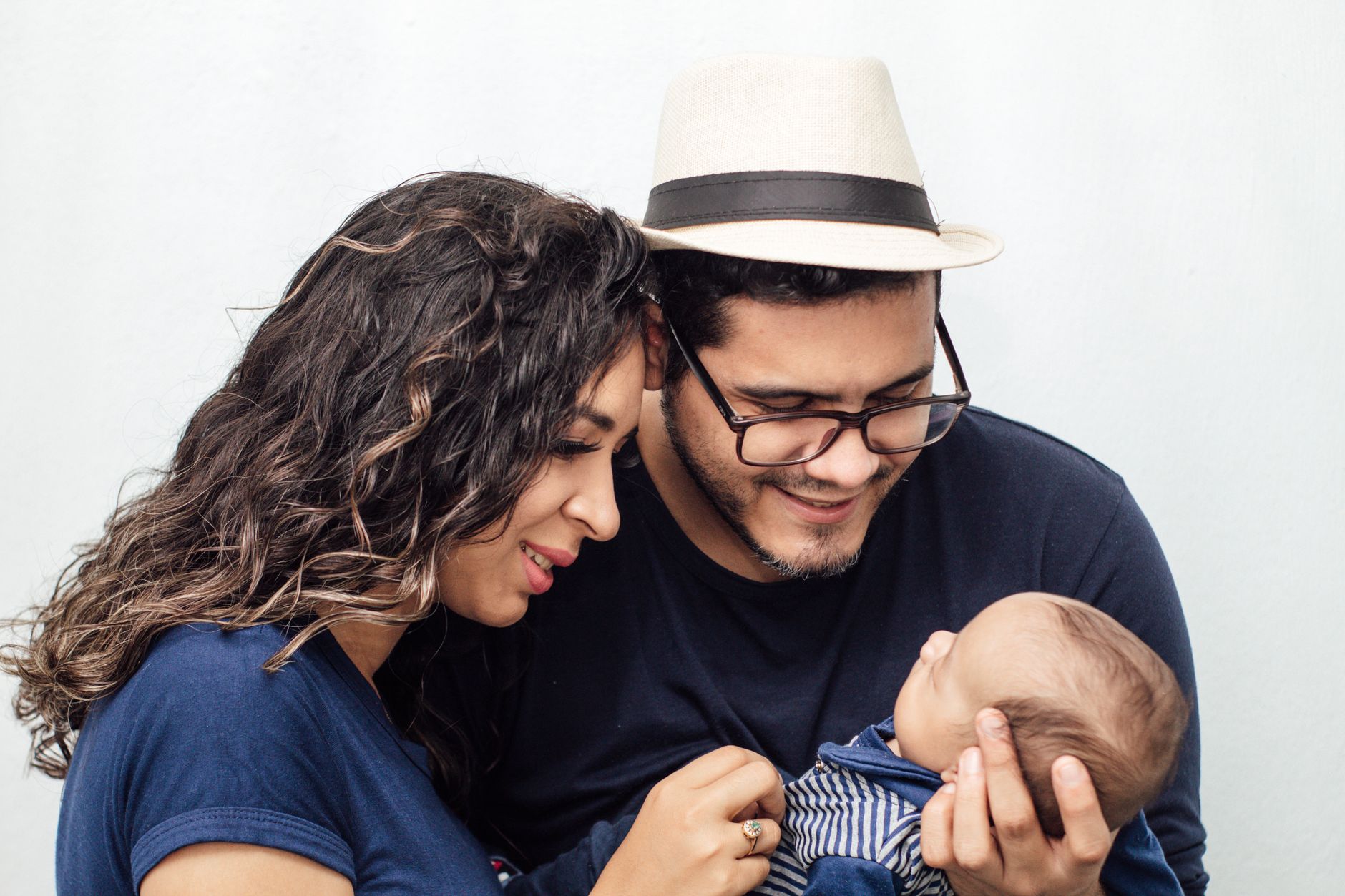 Casal segura carinhosamente o filho recém-nascido em um momento de afeto familiar